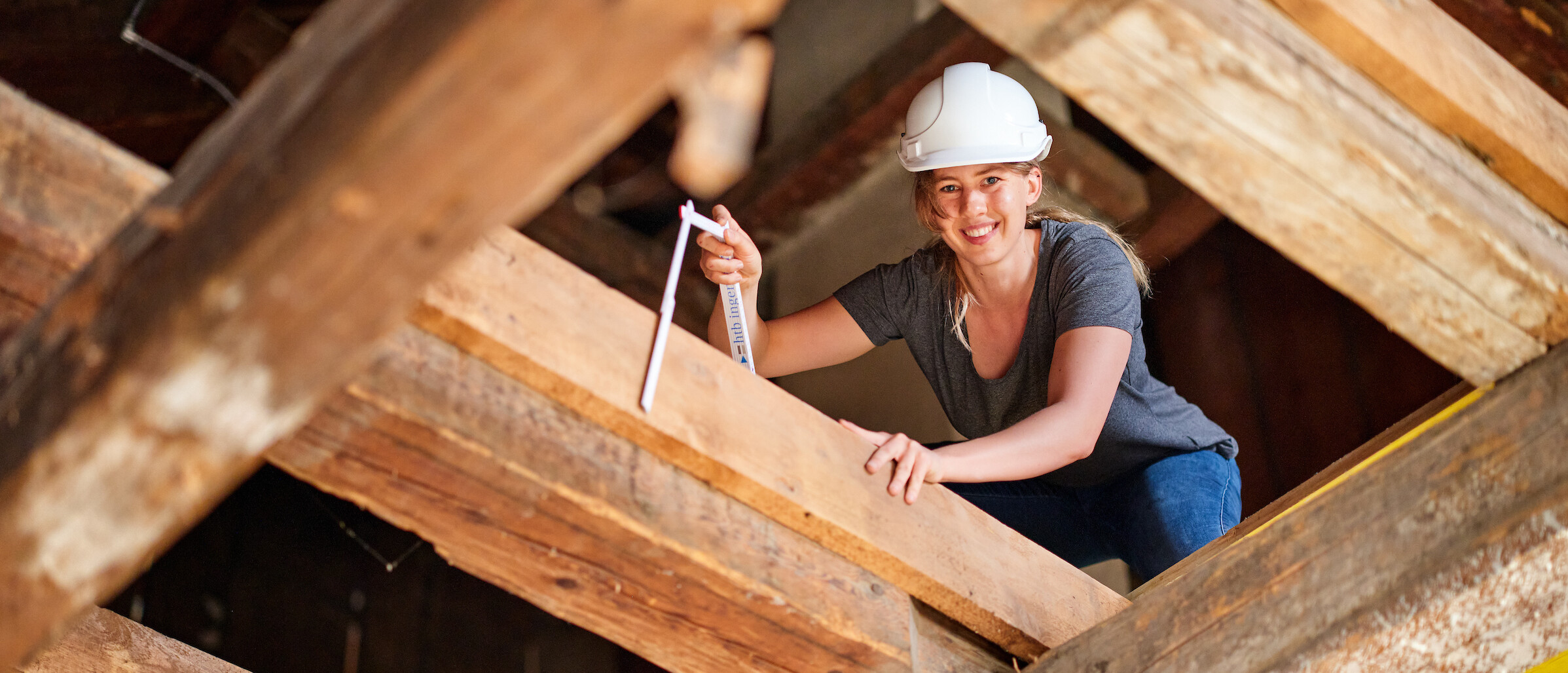 Studentin des Bachelor Bauingenieurwesen auf hölzernen Dachkonstruktion Studentin des Bachelor Bauingenieurwesen auf hölzernen Dachkonstruktion