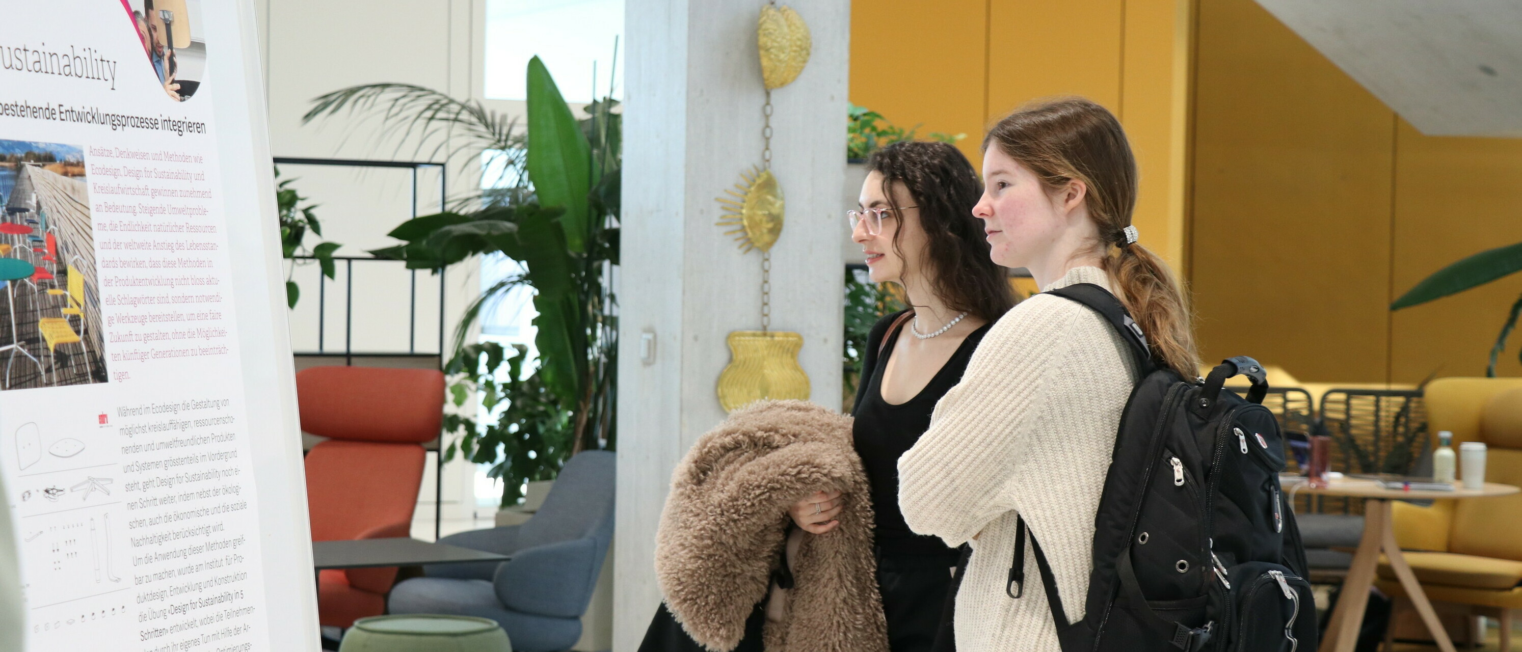 Studierende betrachten das Poster zum Projekt «Design for Sustainability».