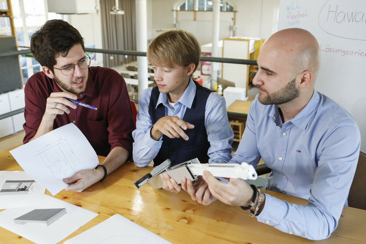 Angehende Wirtschaftsingenieure arbeiten an einem Konzept für einen New-Work-gerechten Arbeitsplatz.
