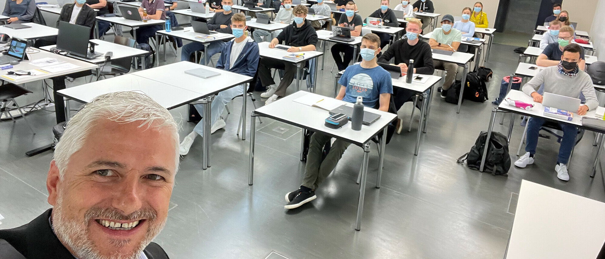 Thomas Metzger, Leiter des Studienbereichs Wirtschaft an der OST, mit Wirtschaftsinformatik-Studierenden