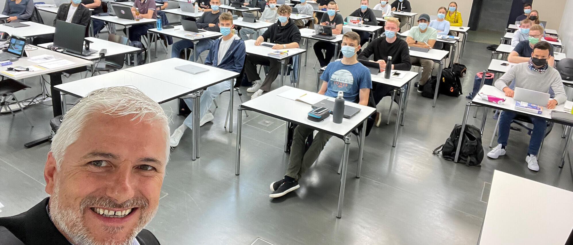 Thomas Metzger, Leiter des Studienbereichs Wirtschaft an der OST, mit Wirtschaftsinformatik-Studierenden