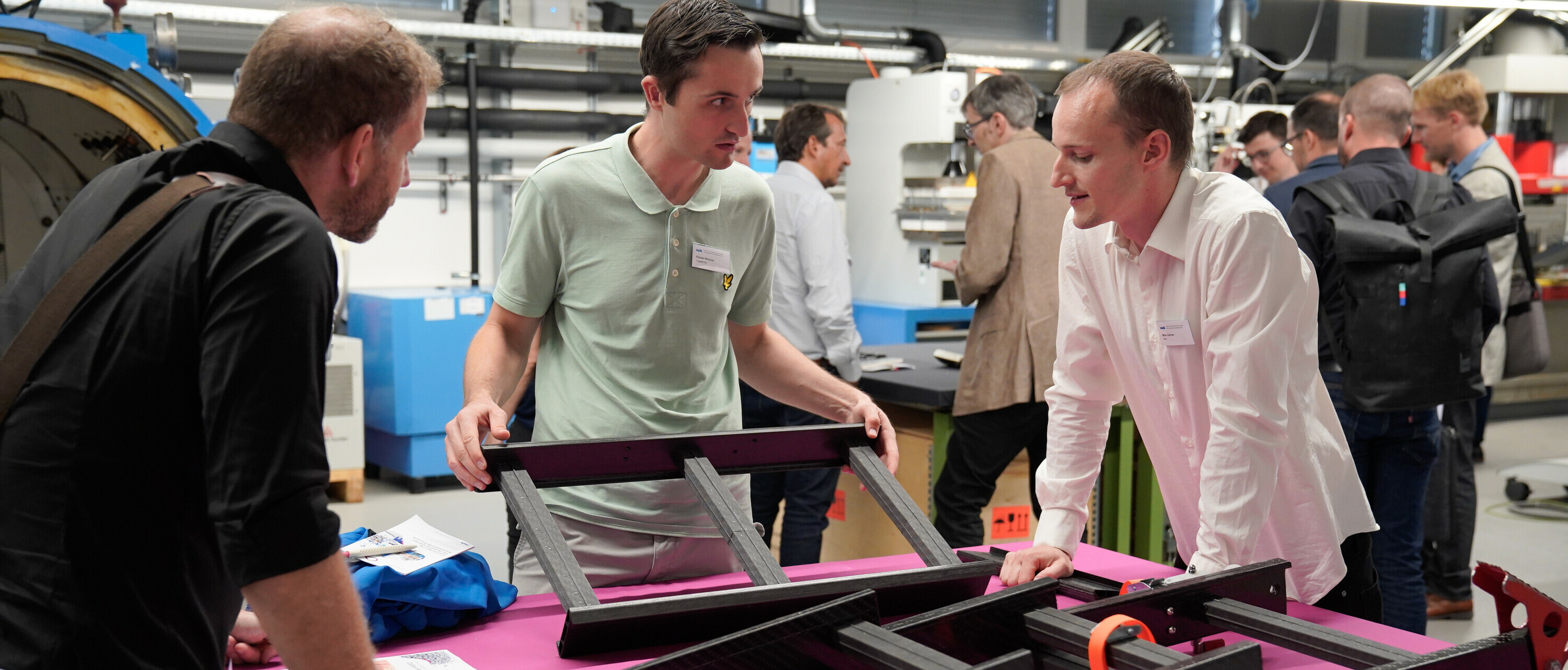 Teilnehmende am 19. Rapperswiler Kunststoff-Forum im Gespräch mit wissenschaftlichem Mitarbeiter zum Thema Faserverbundtechnik / Leichtbau.