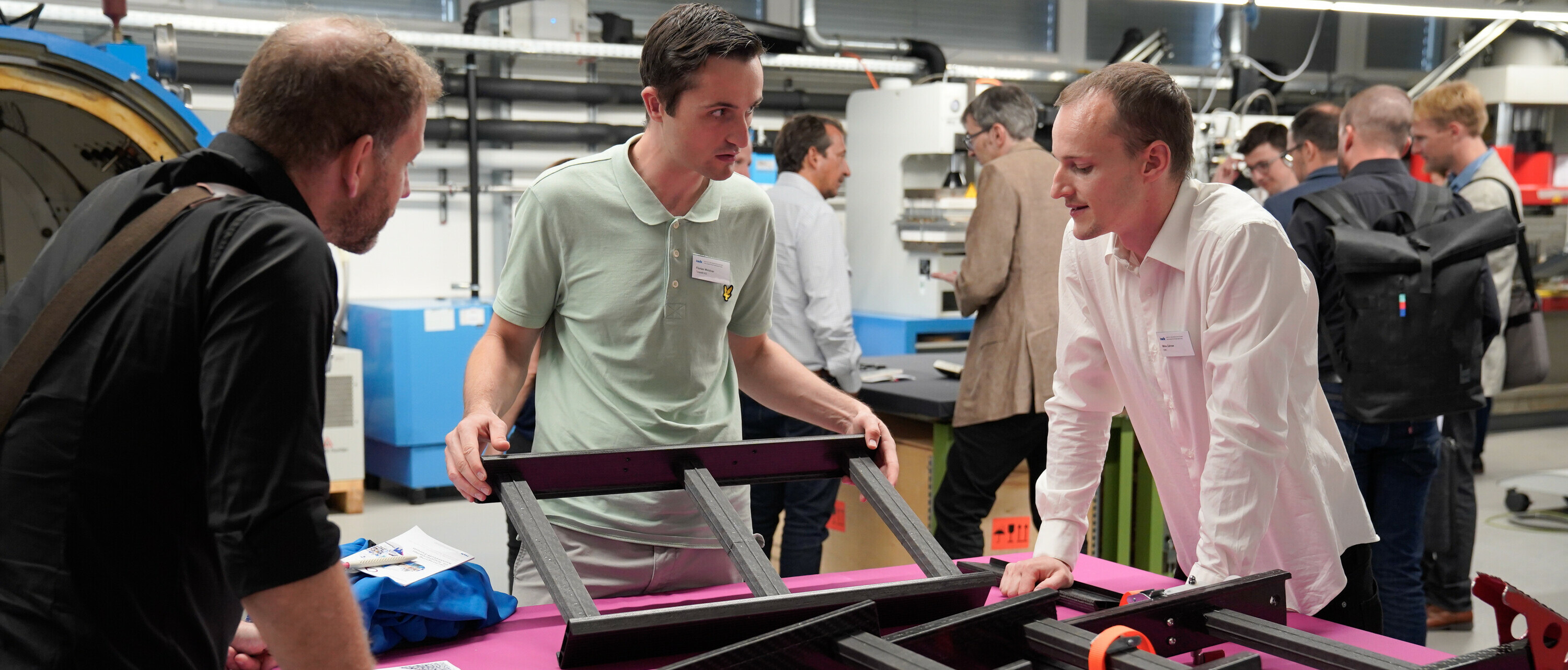 Teilnehmende am 19. Rapperswiler Kunststoff-Forum im Gespräch mit wissenschaftlichem Mitarbeiter zum Thema Faserverbundtechnik / Leichtbau.