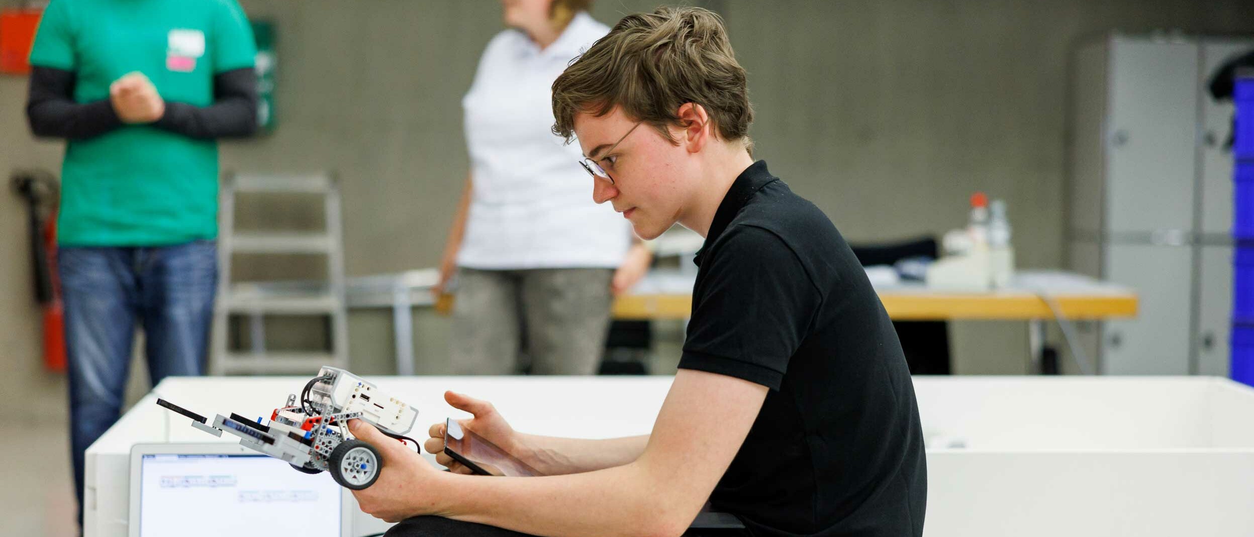 Ein Schüler prüft seinen Roboter vor dem Wettkampf