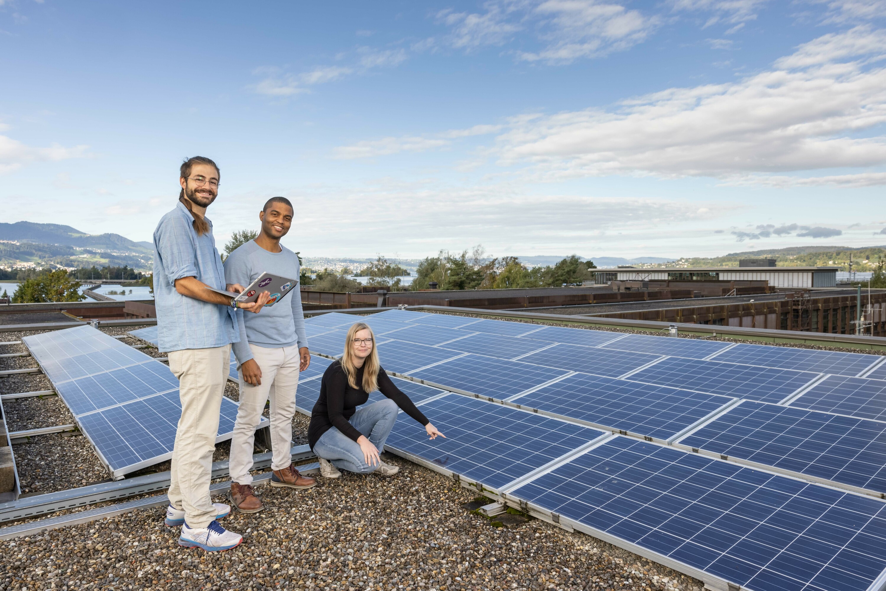 Studierende neben Photovoltaik-Anlage auf dem Dach der OST Rapperswil