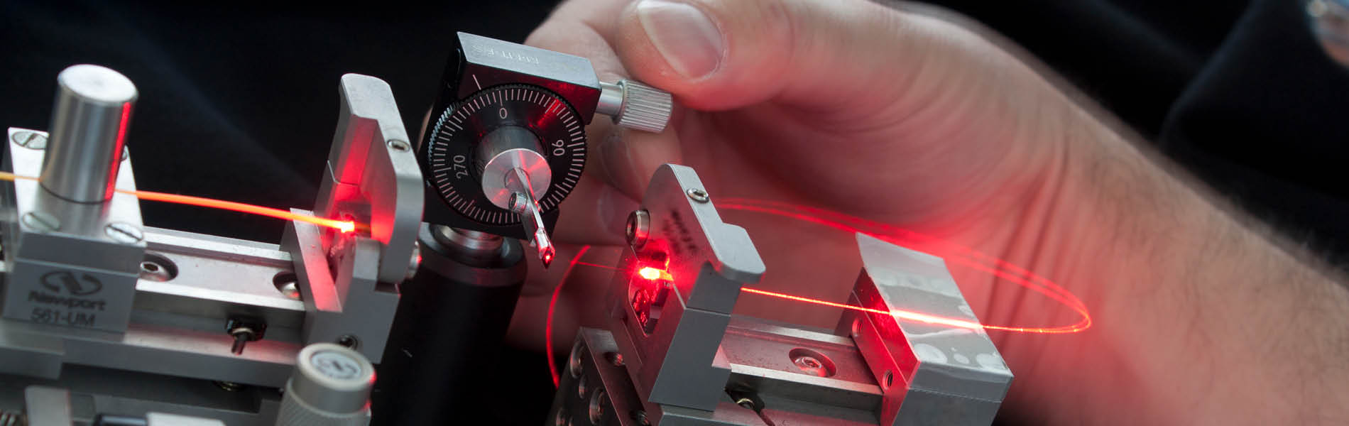 Eine Hand hält als Beispiel von Photonik (Photonics) ein Lichtwellenleiter