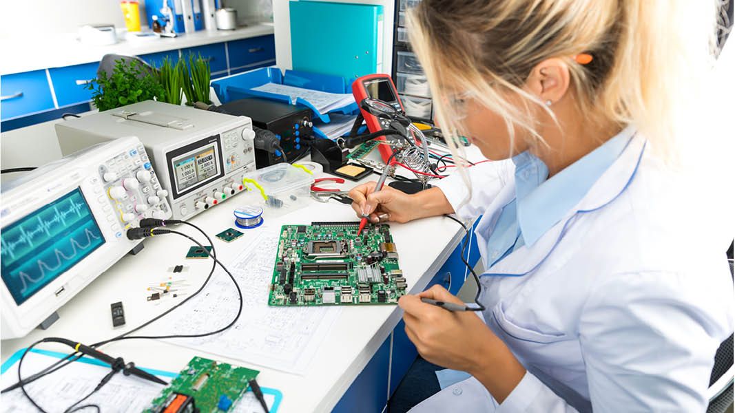 Junge Frau vor elektronischen Messgeräten