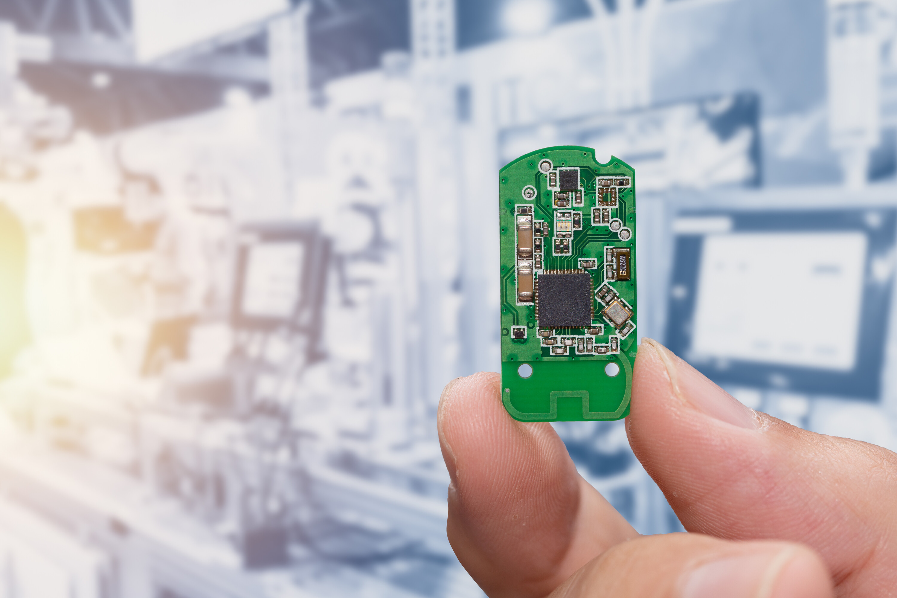 Hand hält eine Platine als Beispiel für ein Embedded Systems 
