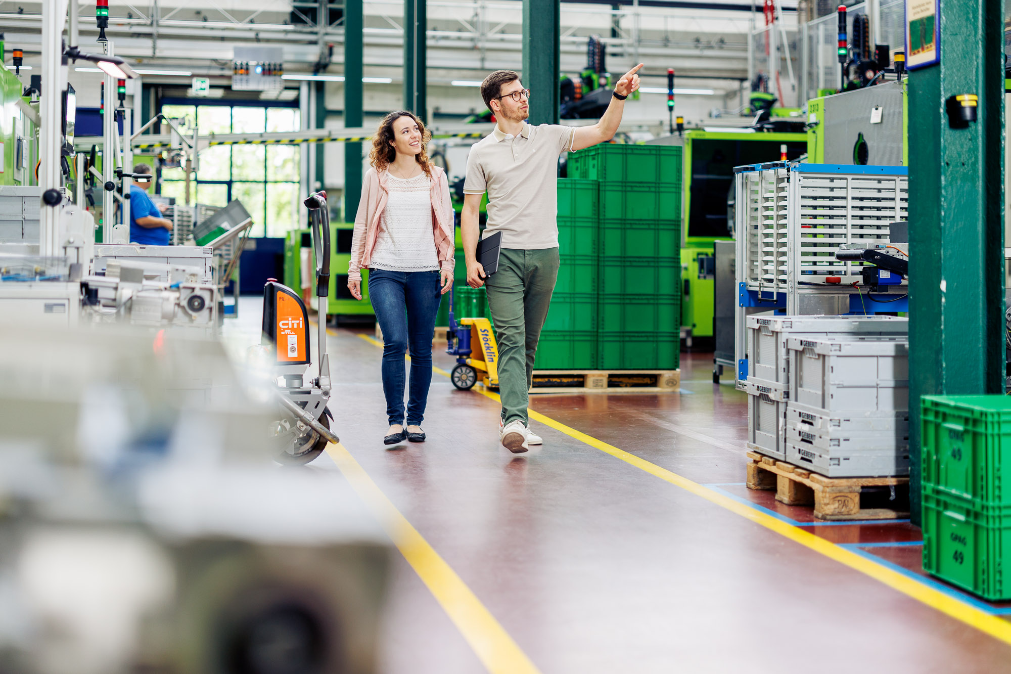 Zwei zukünftige Wirtschaftsingenieure inspizieren die Fabrikhalle eines Unternehmens und diskutieren über die Smart Factory.