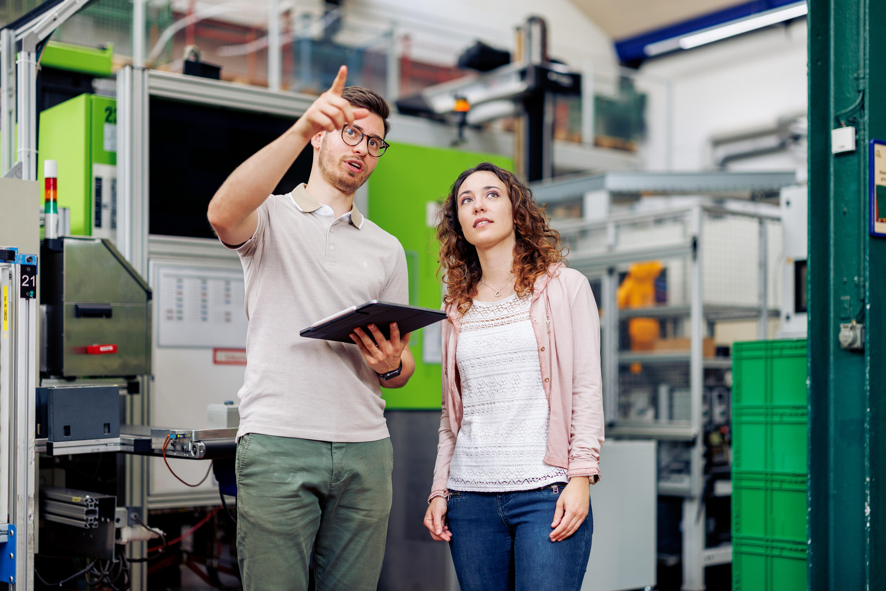 Studierende des Studiengangs Wirtschaftsingenieurwesen diskutieren in einer Produktionshalle über die Digitalisierung der Industrie.