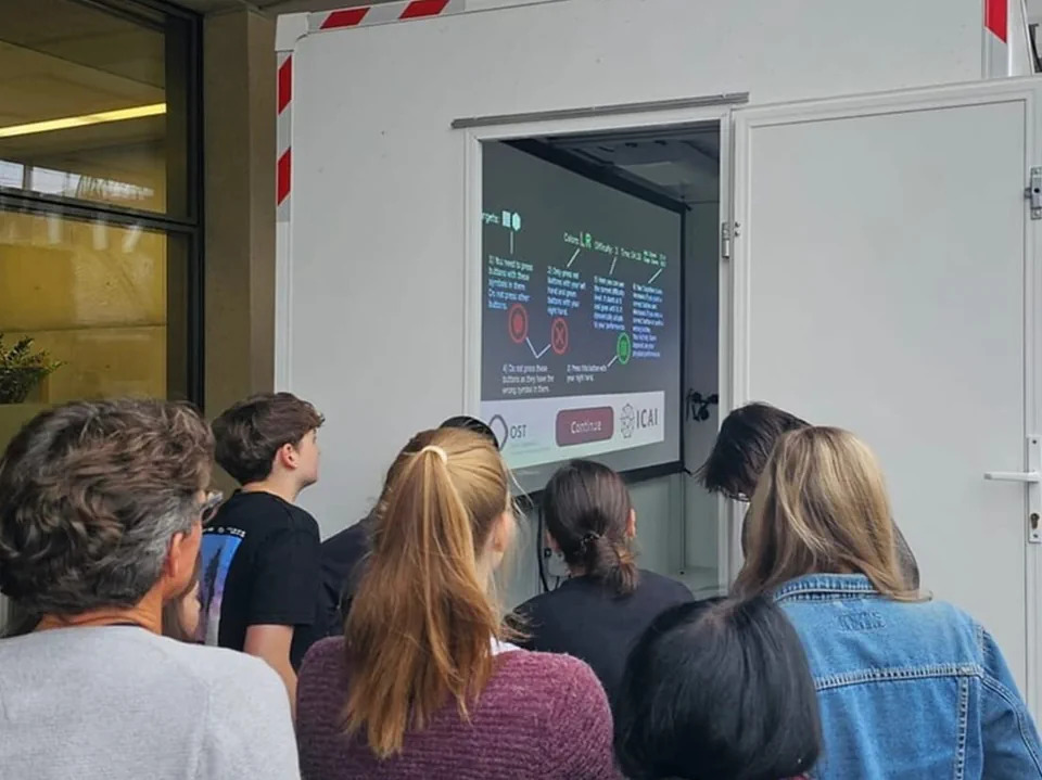 Menschengruppe vor dem Eingang einem Anhänger, der exekutive Funktionen (EFC) mittels künstlicher Intelligenz trainieren kann.